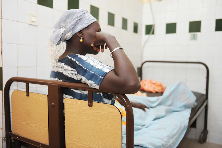 Une femme africaine est sur un lit après son accouchement