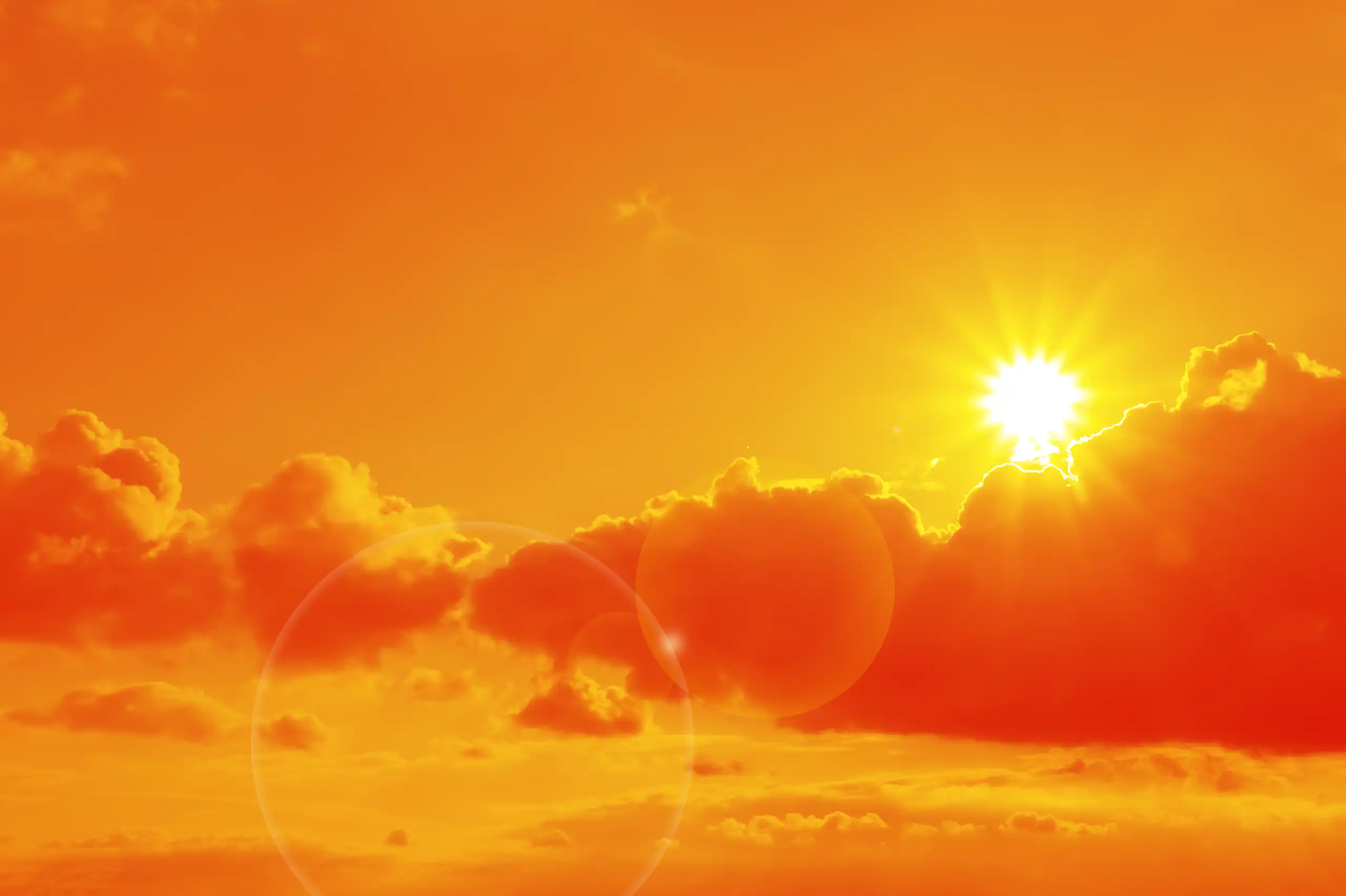 Sun and clouds in an orange sky.