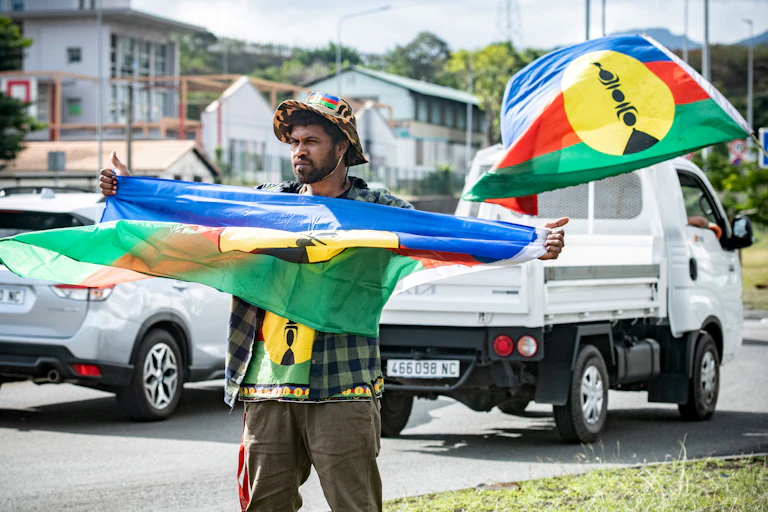Un partisan de l'indépendance sur le bord d'une route avant les élections législatives dans le district de la Vallée du Tir à Nouméa en Nouvelle-Calédonie, le 27 juin 2024.