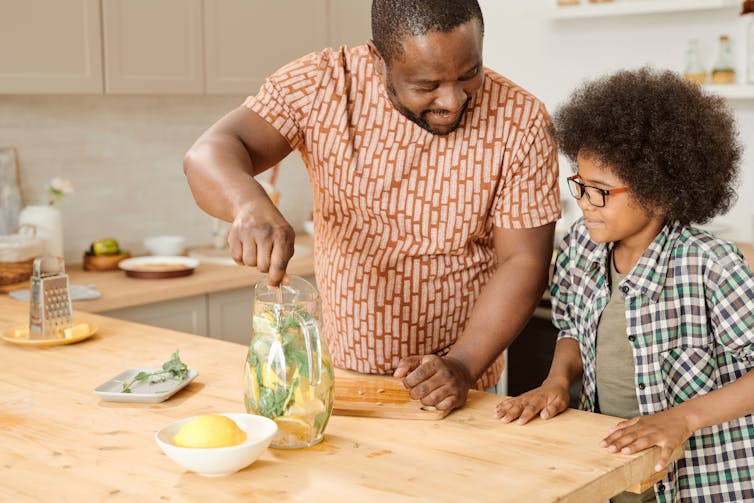 man and child at kitchen counter making lemonade