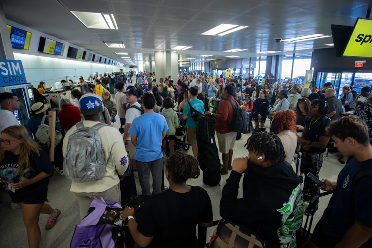 A massive crowd of passengers mills around at Newark Liberty International Airport.