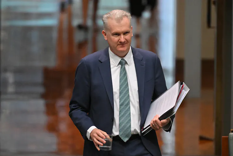 A man in a suit and tie walks in parliament house