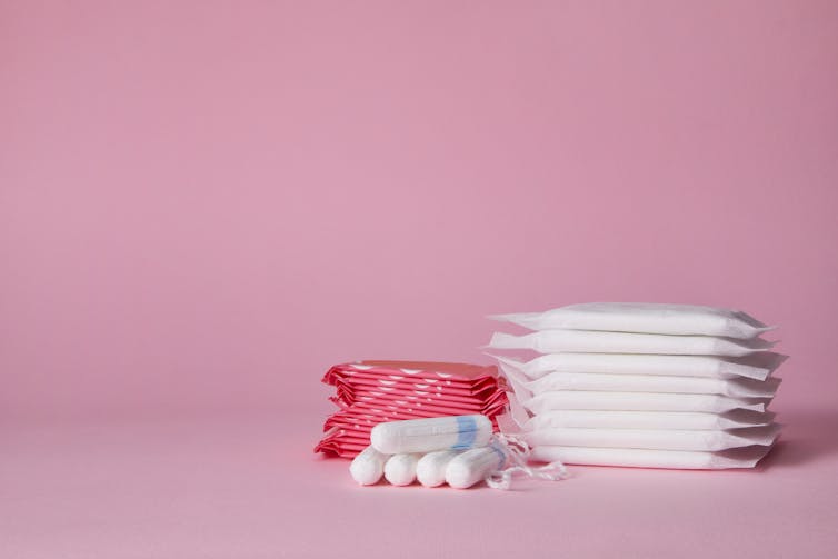 Small collections of sanitary pads and tampons against a plain background.