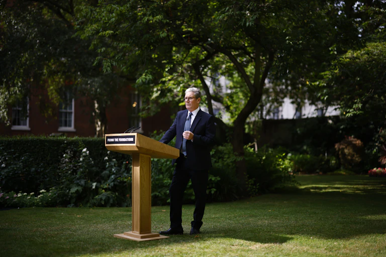 Keir Starmer standing at a podium in a garden.