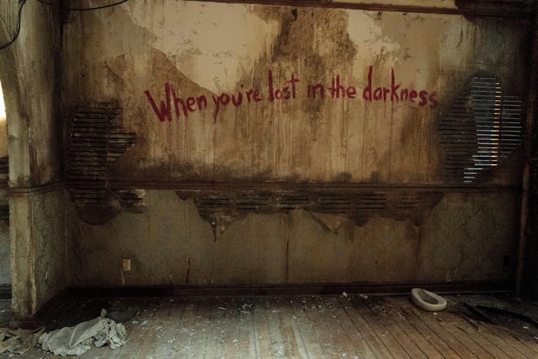 A stained wall bearing the words: When you're lost in the darkness.