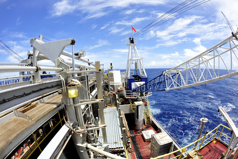 View from atop a large ship, with masts and equipment