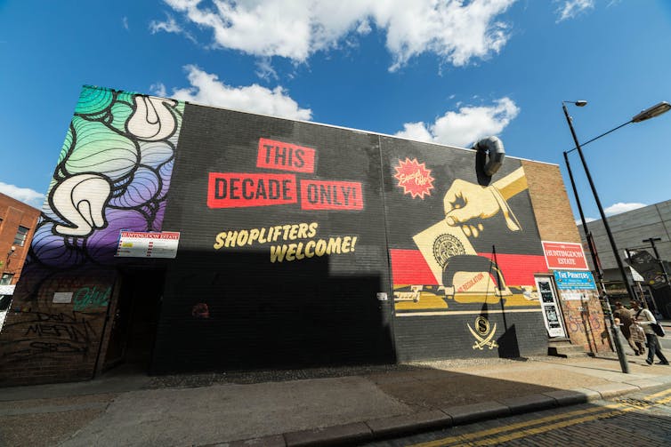Artistic graffiti on a building in east London says 'shoplifters welcome!'
