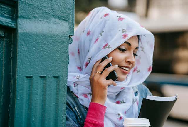 techniques used in cancer research A young woman in a white floral head scarf smiling talking on a phone.