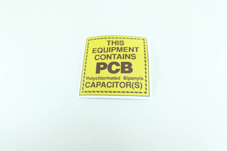 small yellow label: black font This equipment contains PCB capacitors