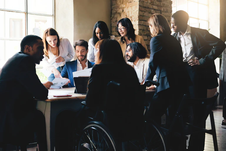 Une équipe diverse réunie autour d'un bureau dans un bureau aux allures de loft