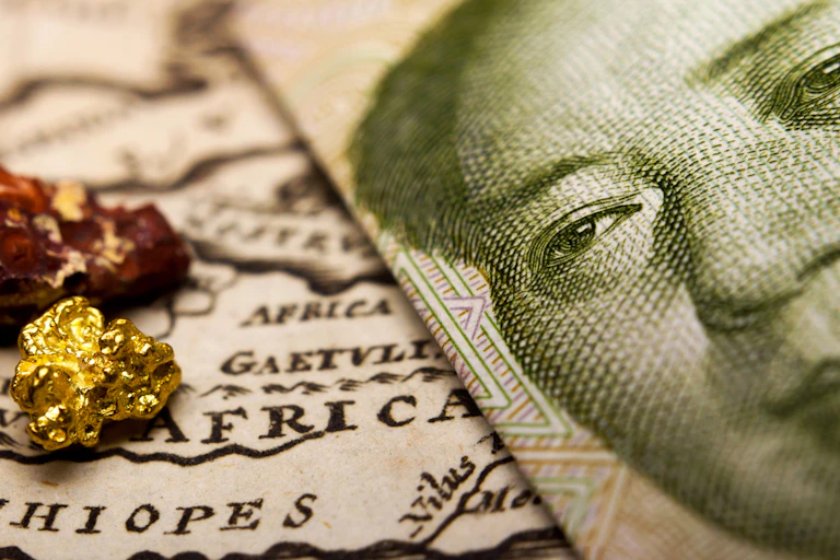 Chinese banknote and a gold nugget and rare earth metal on map of Africa