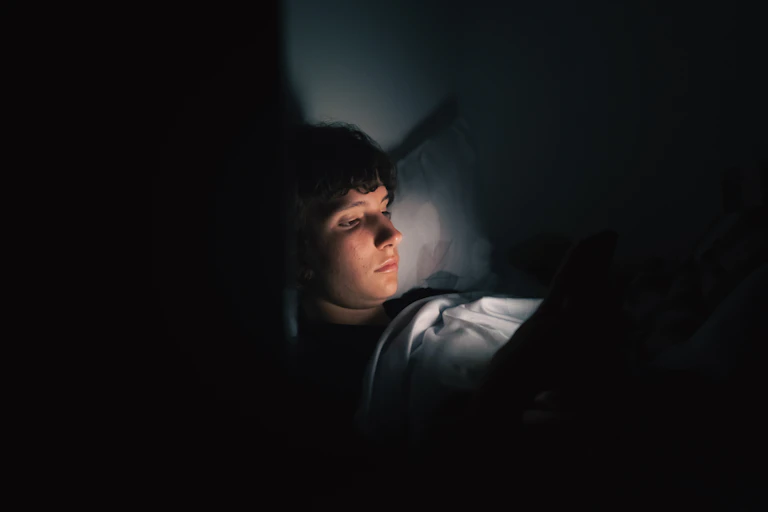 Teenager uses gadget in dark