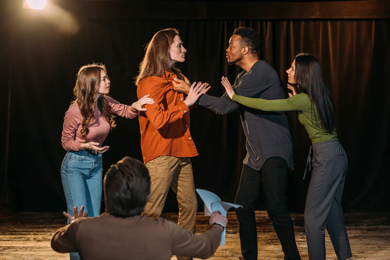 Young drama students practice a play in a theatre.