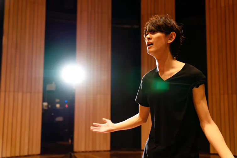 A young actor delivers his lines in a theatre.