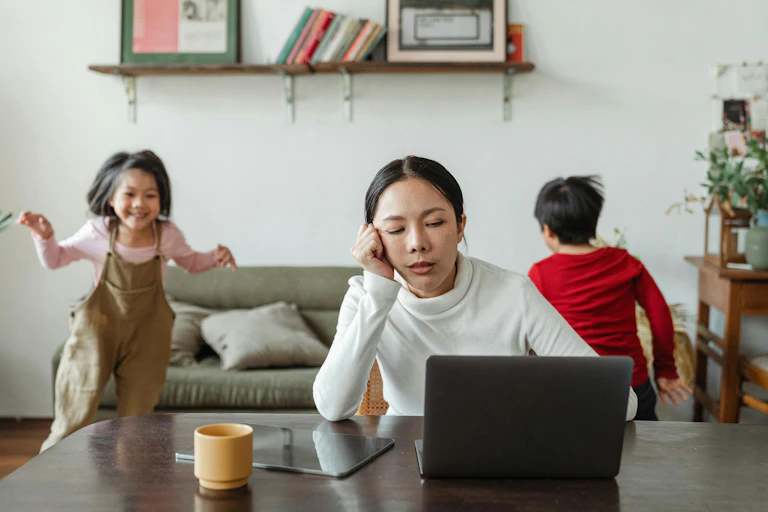 Tired mother sits in front of laptop