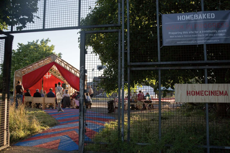 A community space with a tented stage and garden space.
