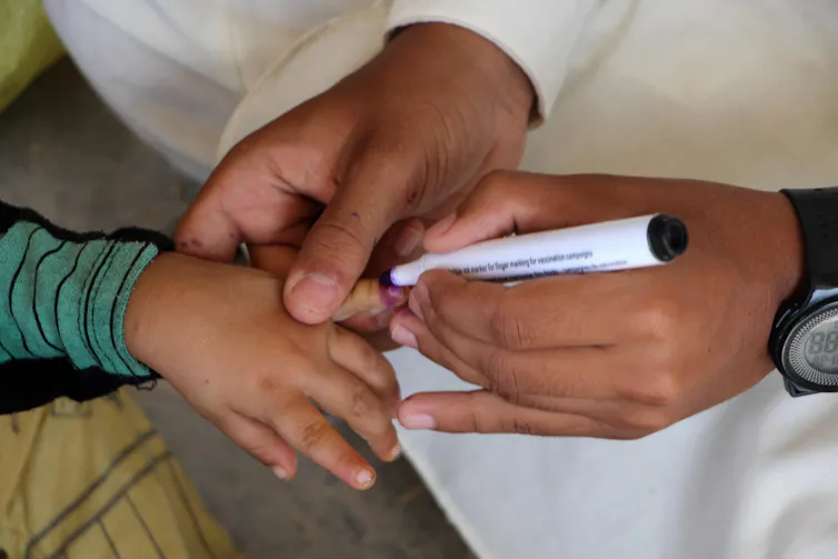 A health worker marks the finger of a child after administering polio vaccination in Kandahar, Afghanistan.