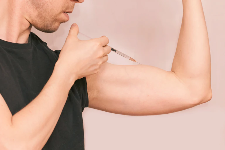 A man injecting a substance into his biceps