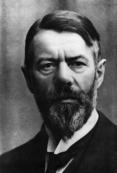 A middle-aged white man with a stern face poses for a portrait.