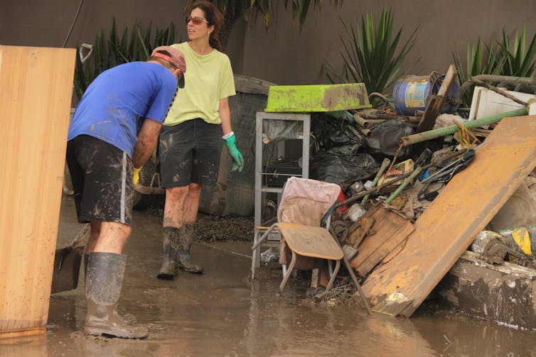 An unidentified man and woman cleaning up a flooded home