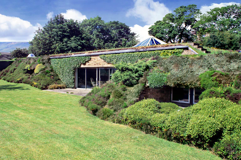 Underground house with garden and plants above, windows at side