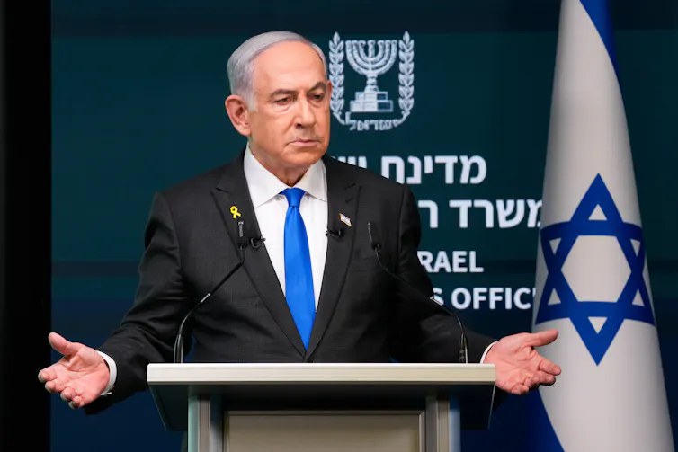 Benjamin Netanyahu giving a speech at a podium.