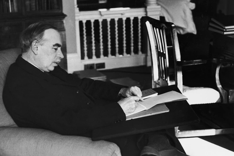Black and white photo of a seated man writing
