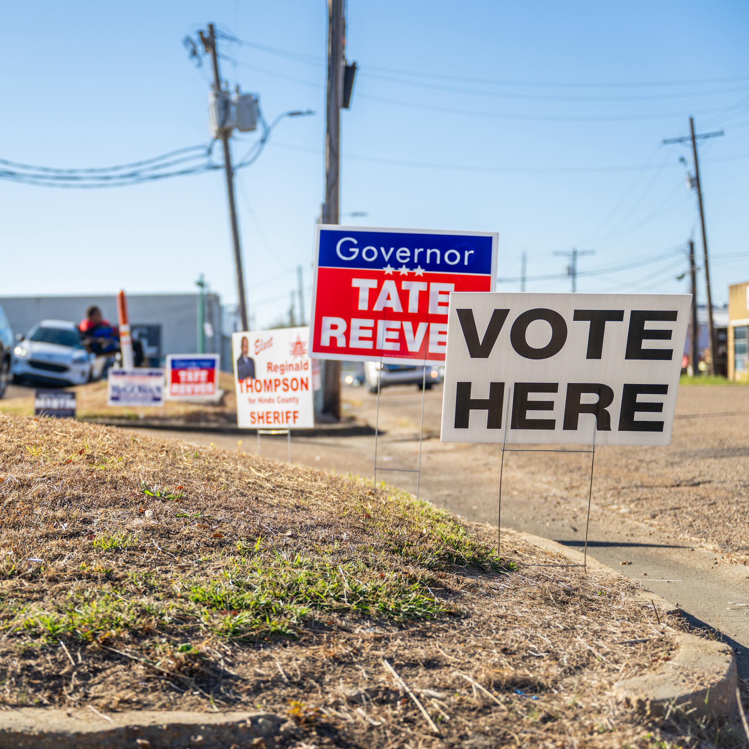 A sign reading Vote Here is seen in a desolate neighborhood.