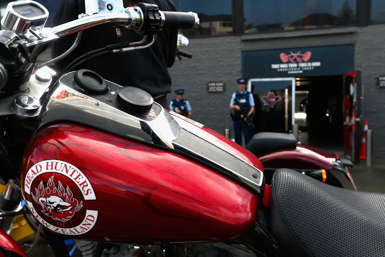 Armed police stand guard as confiscated motorcycles are removed from a boxing gym run by the Head Hunters gang.