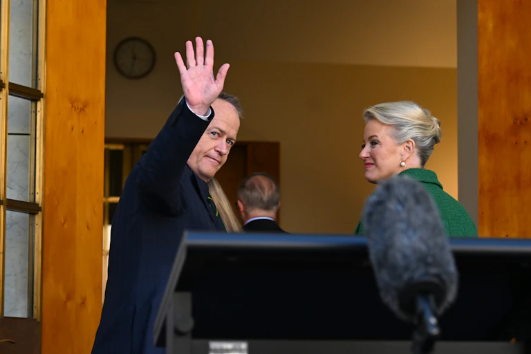 Bill Shorten waves goodbye, standing next to his wife, Chloe