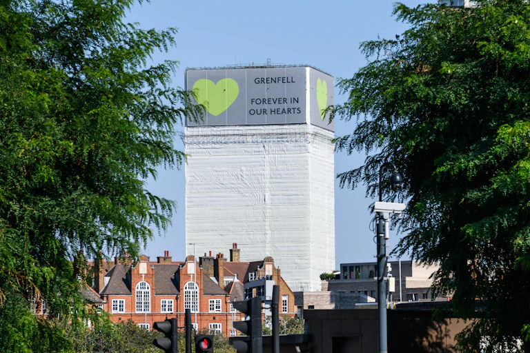 Grenfell Tower covered in a banner that reads 'Grenfell, forever in our hearts'