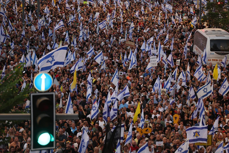 Thousands of demonstrators waving Israeli flags.