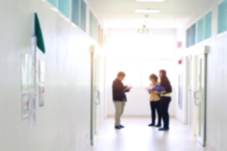 Blurred image of people with clipboards in corridor