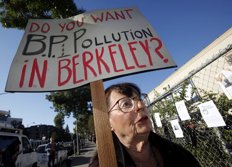 A protestor holds a sign, 'do you want BP pollution in Berekely?'