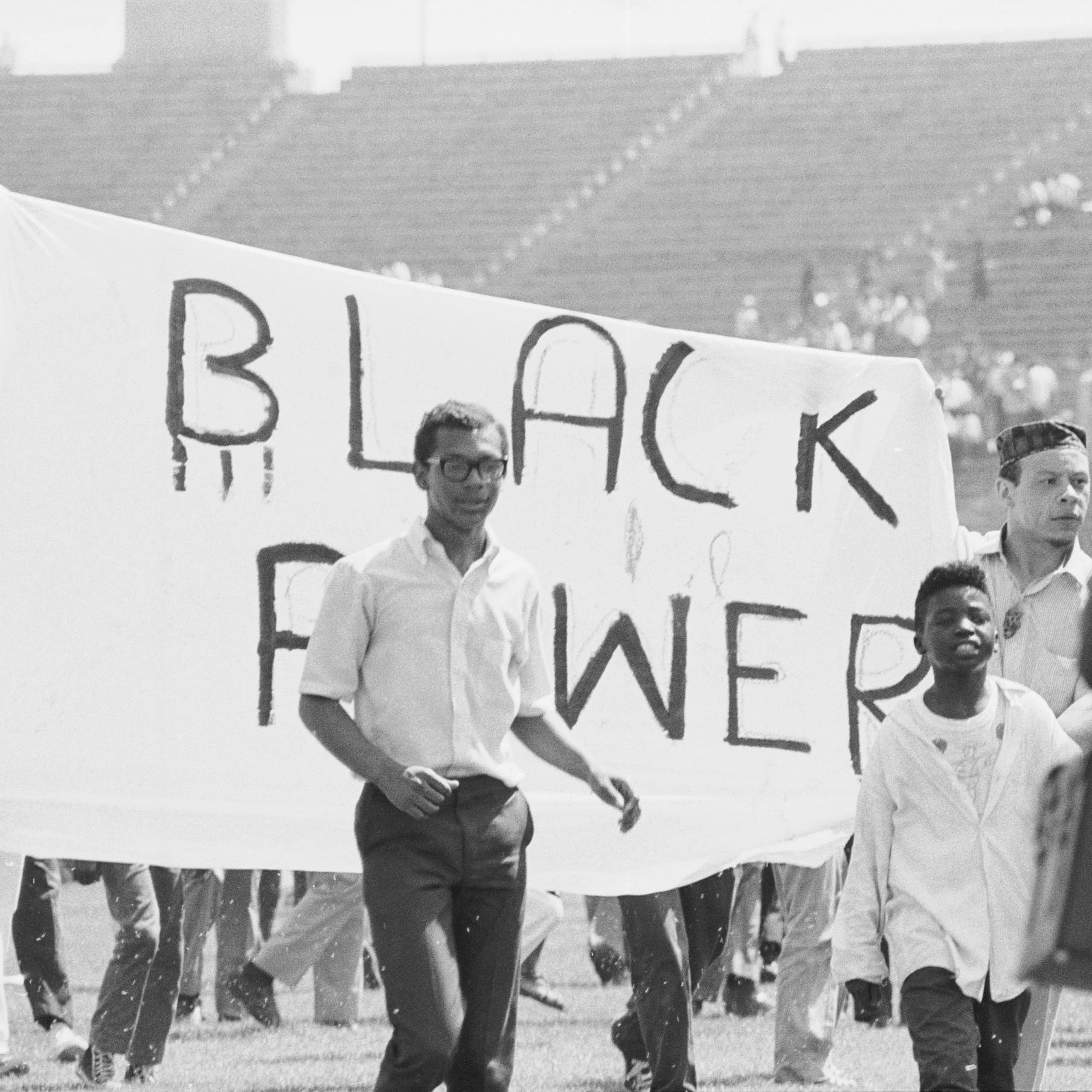 Young Black men holding a banner which says 'Black Power," as they march.