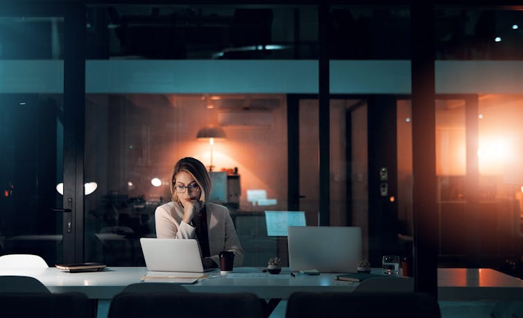 woman sitting alone at her desk at night