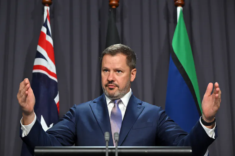 Man speaks to the media at a press conference.