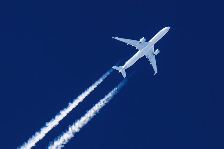 Close-up of jet plane aircraft flying in sky with trails behind