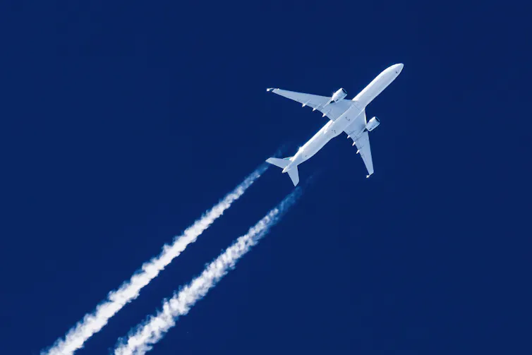 Close-up of jet plane aircraft flying in sky with trails behind