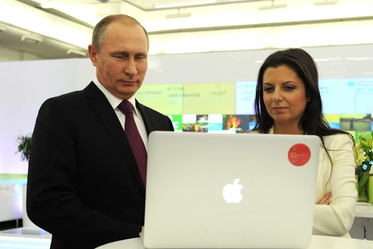 President Putin looking at a laptop with RT editor-in-chief Margarita Simonyan.