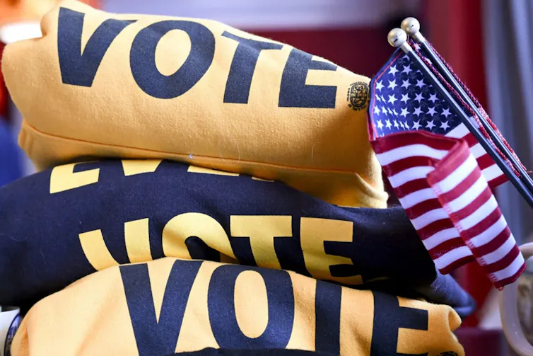 A pile of literature on voting and a US flag.