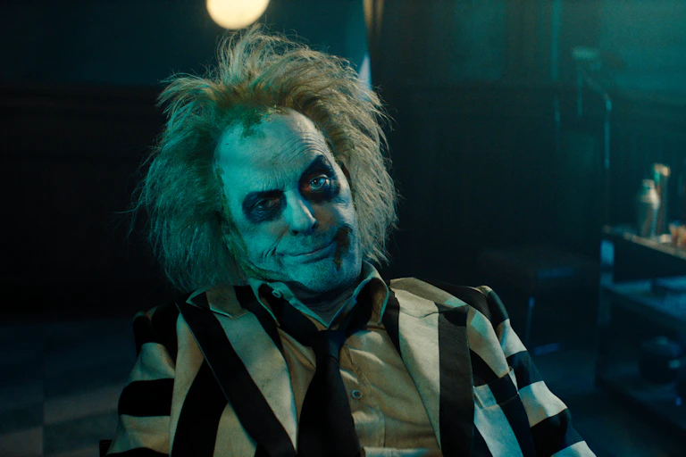 Keaton with heavy makeup in a striped suit