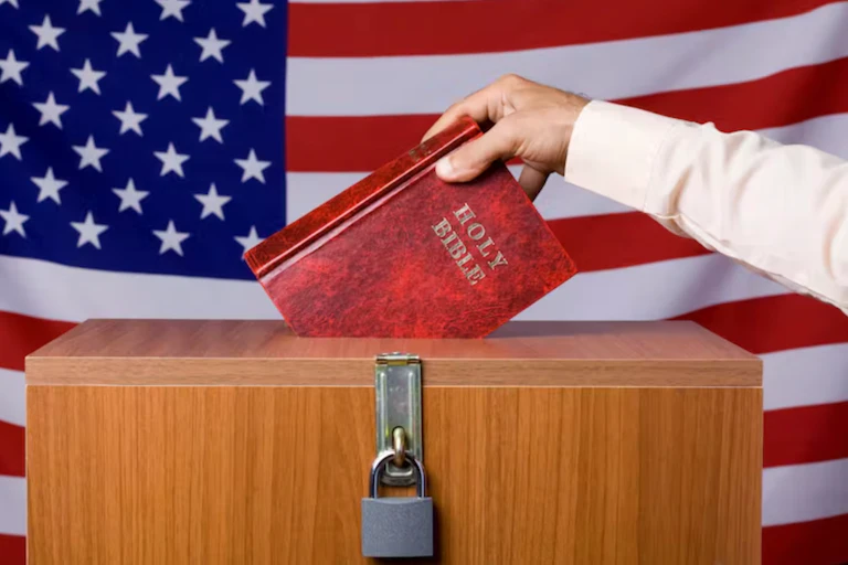 A human hand inserting the Bible into a locked ballot box, behind which is the American flag.
