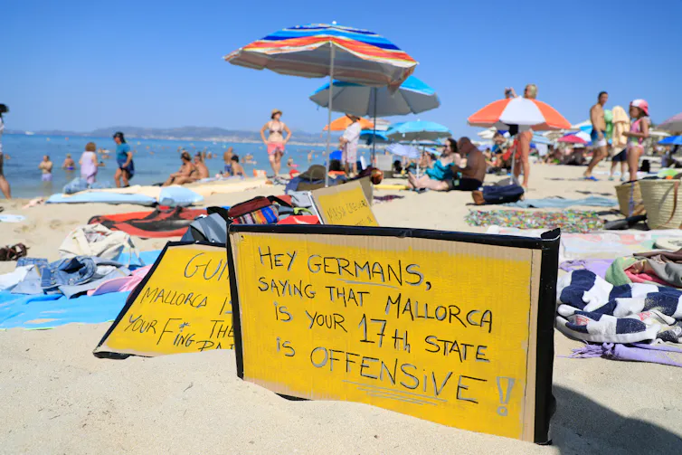 Protest sign on beach in Mallorca saying
