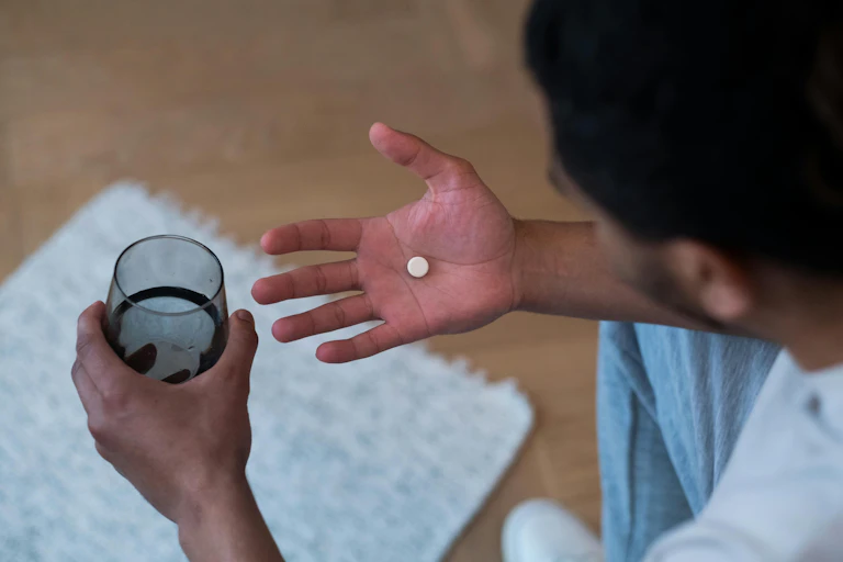 Man looks at medicine in hand
