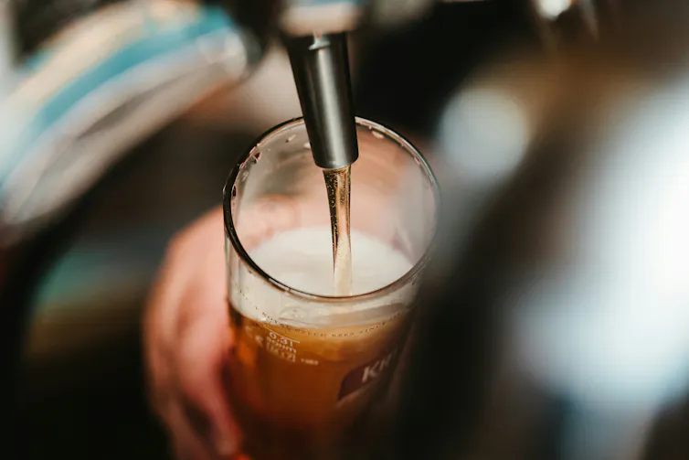 verre qui est en train d’être rempli de bière