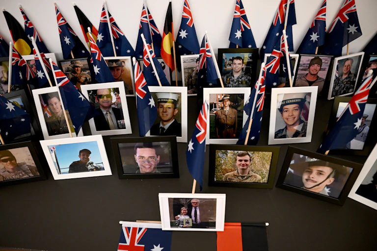 The framed photos of defence men and women, surrounded by Australian and Aboriginal flags