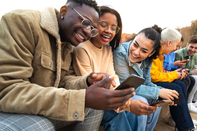 Group of young people smiling at phone