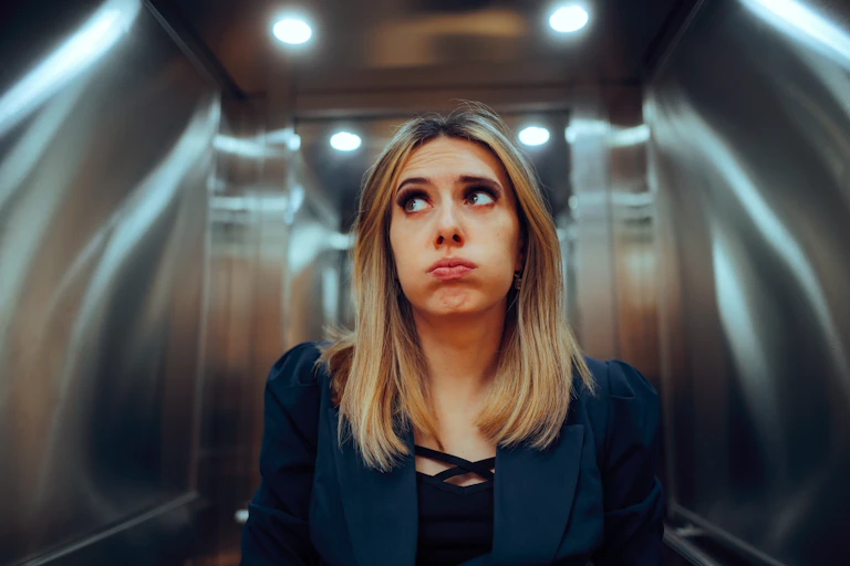 woman in a lift looking fed up