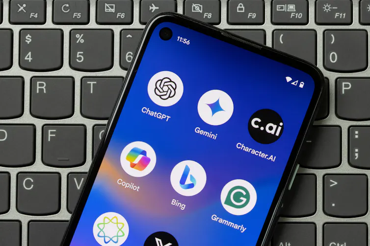 A mobile phone resting on a keyboard with several AI apps.